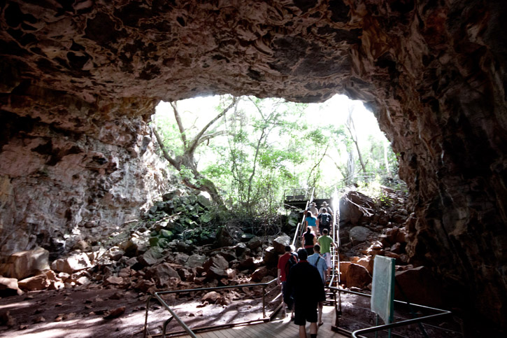 Visitors exiting a large lava tube at Undara National Park.