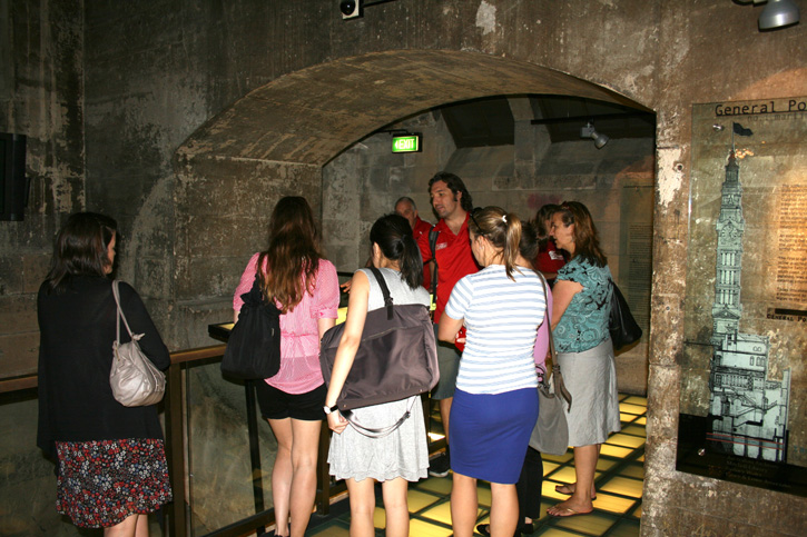A tour guide answers questions for the women in his tour group.