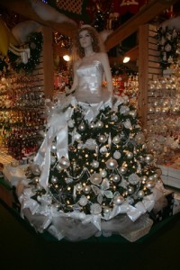 A mannequin whose dress is made up of a christmas tree hung with ornaments.