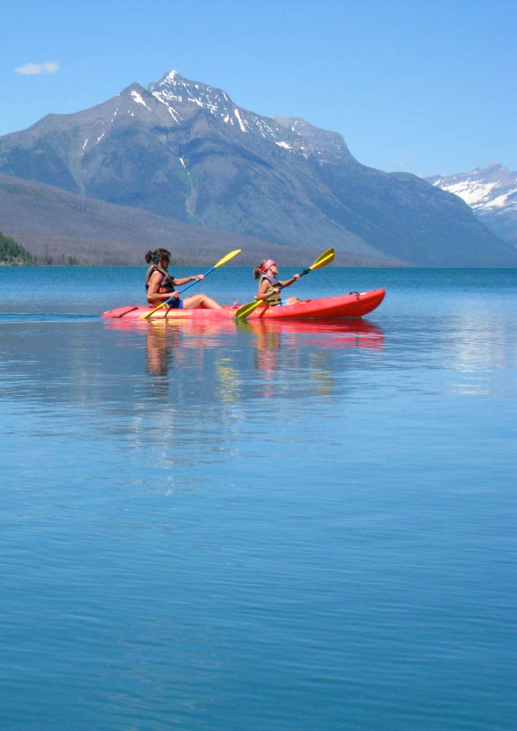 Paddling on the calm surface of Lake McDonald on a sunny day.
