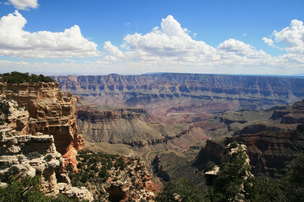 Dramatic view of the Grand Canyon, with the thin snaking line of the Colorado River visible at the bottom.
