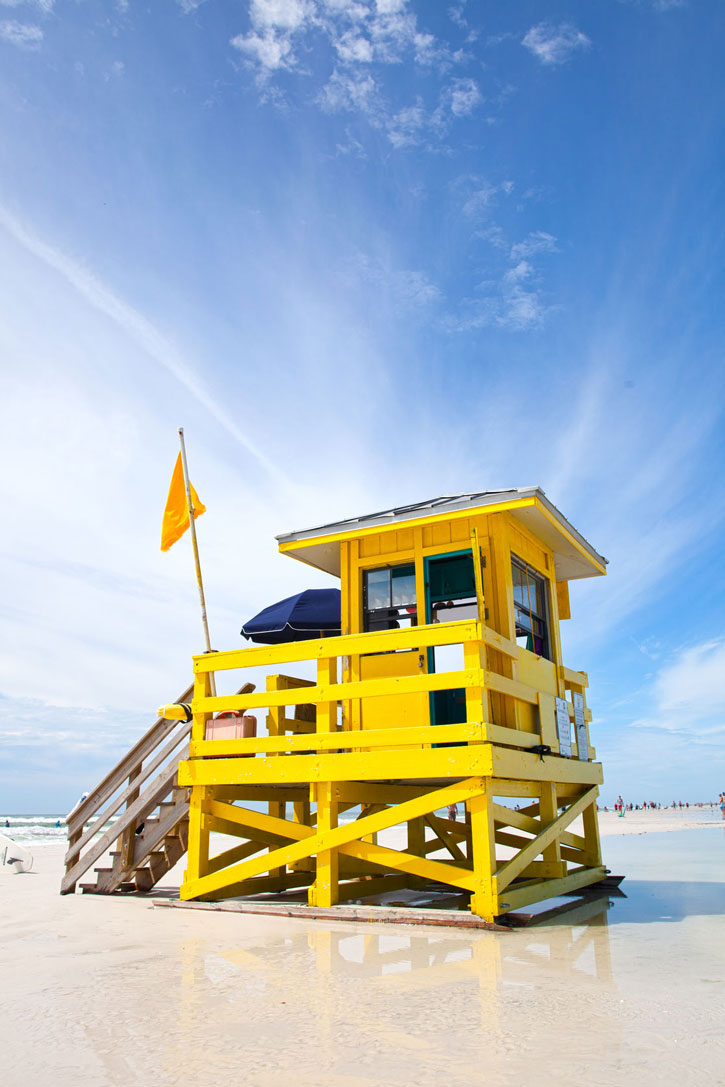 A colorful lifeguard station on the white sand of Siesta Beach.