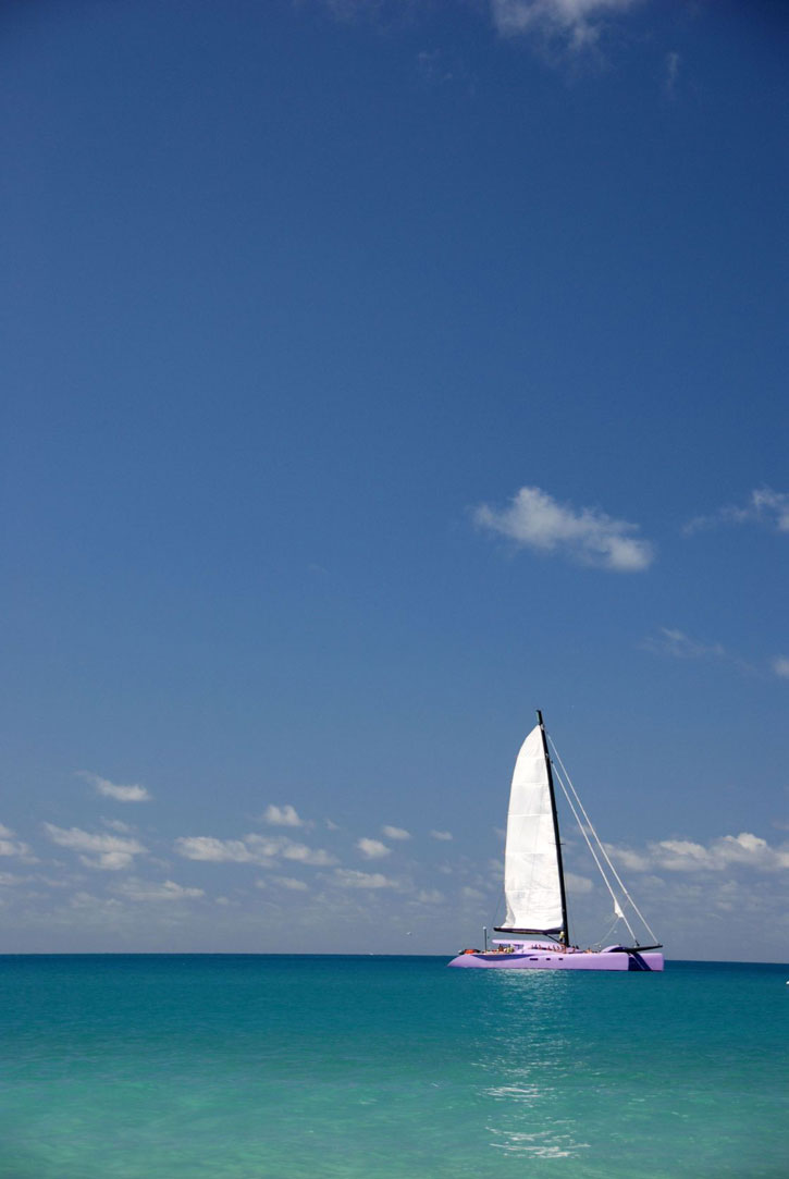A sailboat sits in beautiful turquoise water in Australia's Great Barrier Reef.