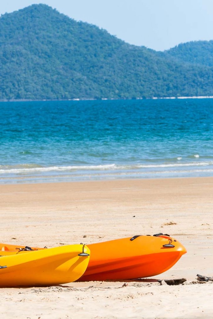 Kayaks waiting on the sand at Mission Beach in Cairns, Queensland.