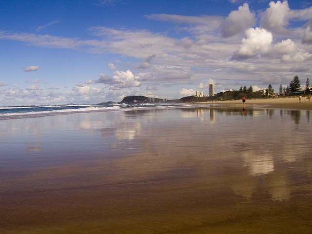 The sky and horizon are reflected in the water at Miami Beach in Queensland.