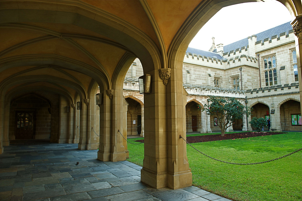 An arcade runs alongside a grassy patch on the Melbourne University's grounds.