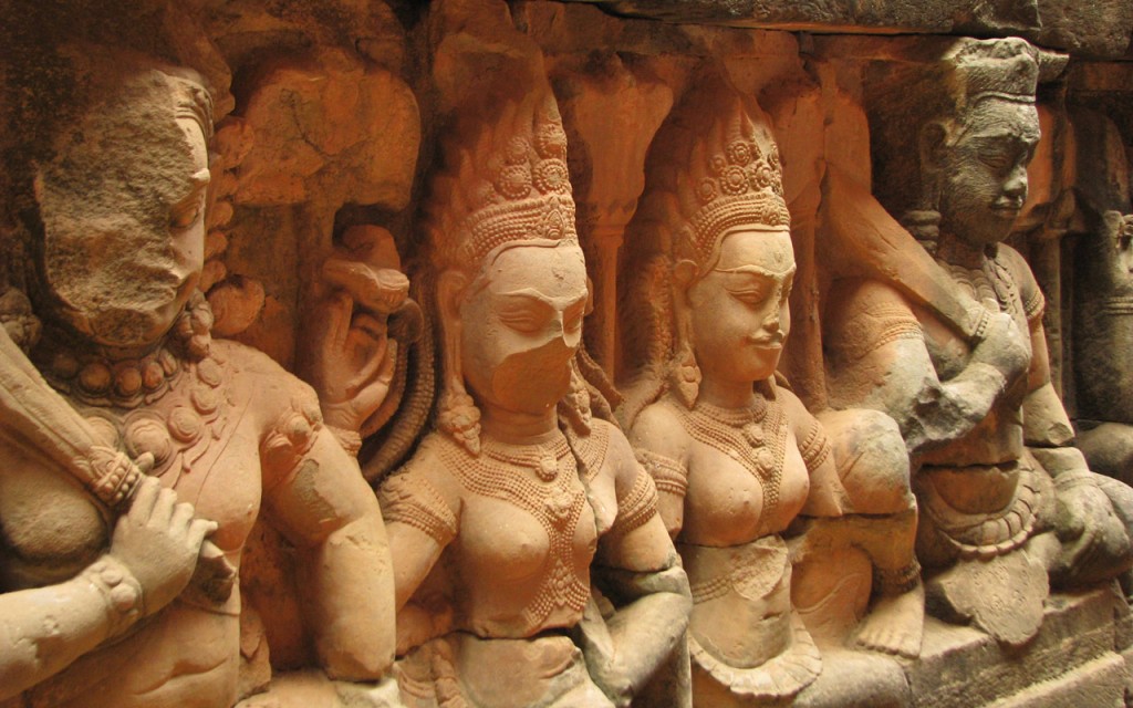 Carved relief sculptures of men and women, some of the stone faces have fallen away.