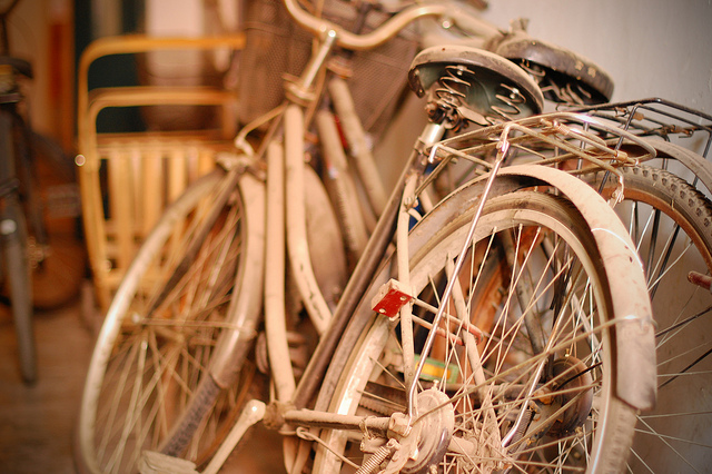 Two bicycles leaned against the wall gathering dust.