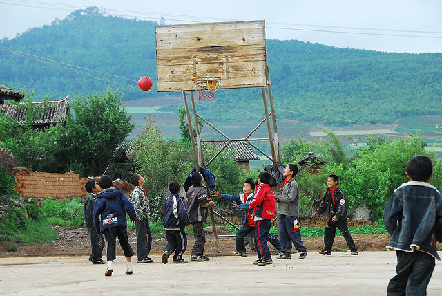 A group of children playing basketball in China.