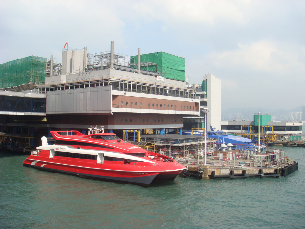 A red hydrofoil jet boat is docked at the Macau ferry terminal.