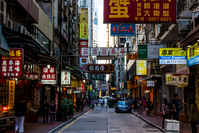 A view of a narrow street bristling with signs in Hong Kong.