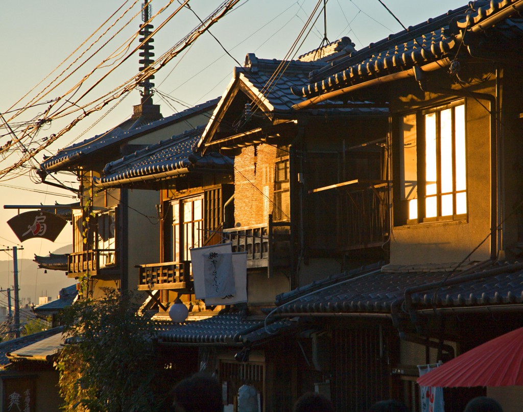 The setting sun reflects agains second-story windows in wood-paneled homes.