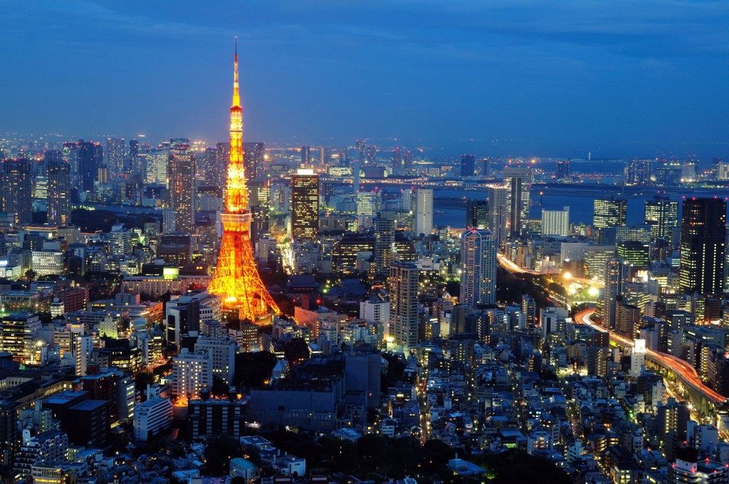 View across Tokyo at night with the buildings all lit and Tokyo Tower rising up dramatically.