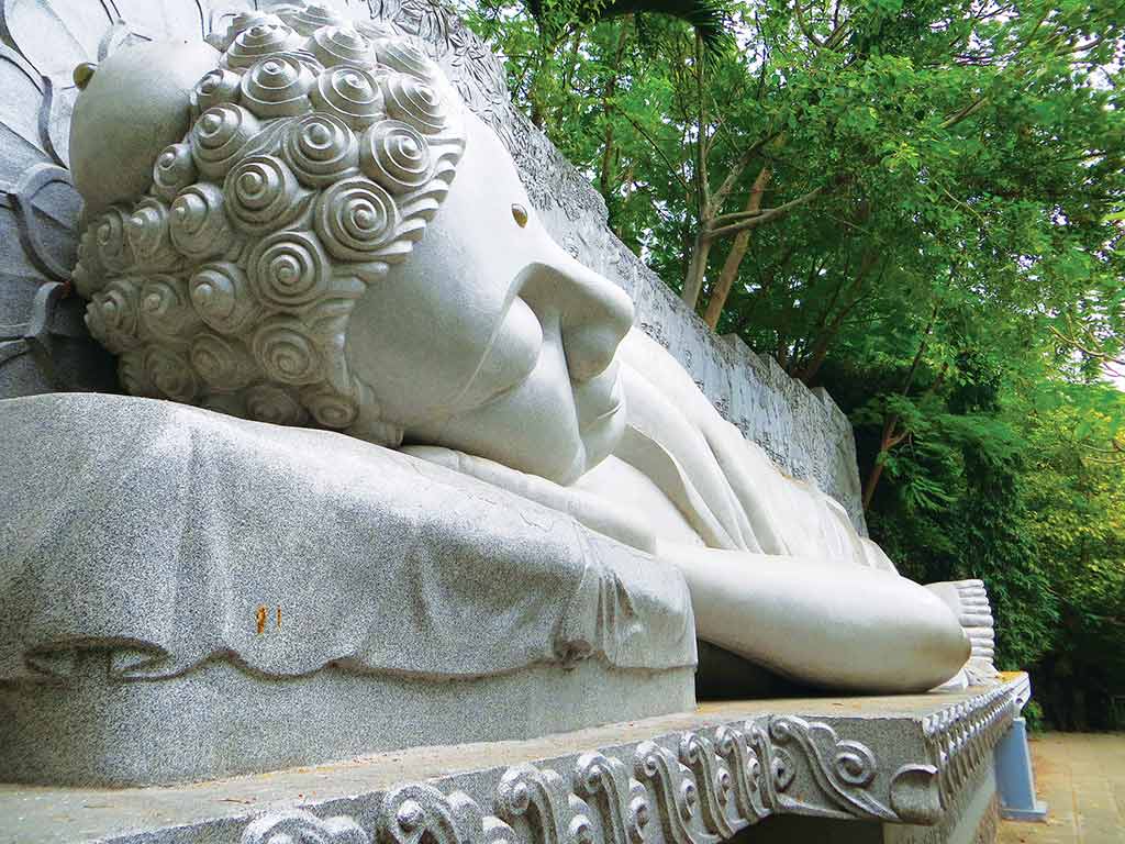 Statue of reclining Buddha on a hillside above Long Son Pagoda. Photo © Dana Filek-Gibson.