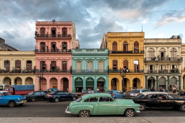 One of Havana's public taxis stopping in front of a row of colorful buildings on the Paseo de Martí.