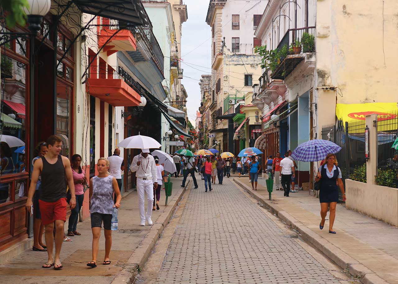 Pedestrians walking along Calle Obispo.