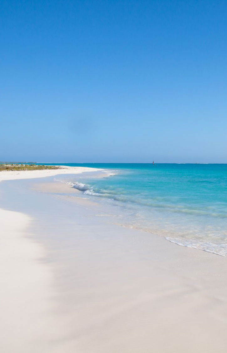 Play Paraiso, a pristine white sand beach under clear skies in Cayo Largo, Cuba.