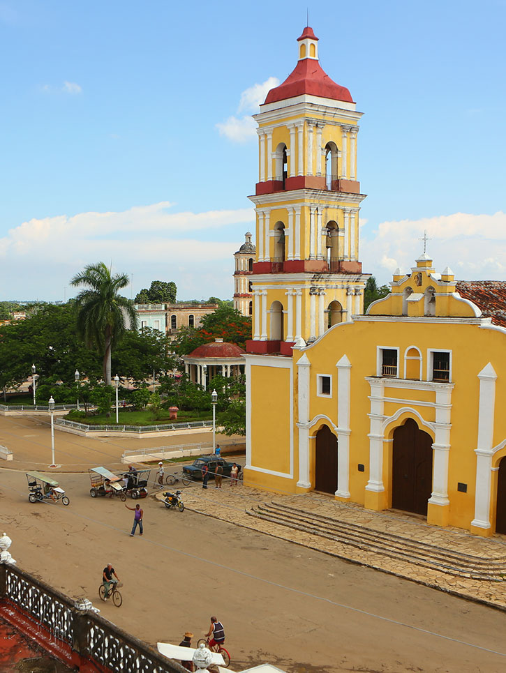 Parroquia de San Juan Batista is a yellow church with a three-tiered belltower in Remedios Cuba.