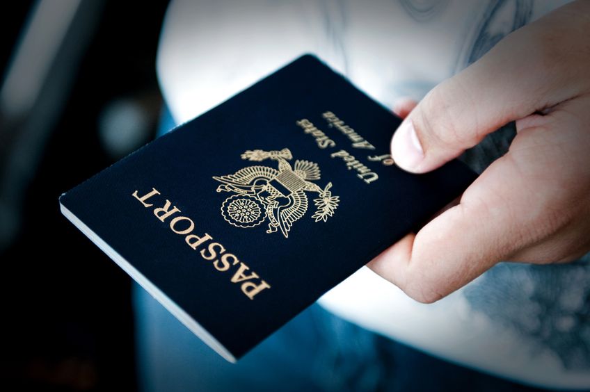 Photo of a U.S. passport in a traveler's hand.