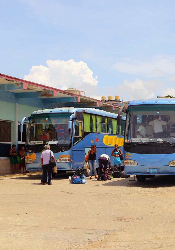 Passengers board colorful buses in Cuba.