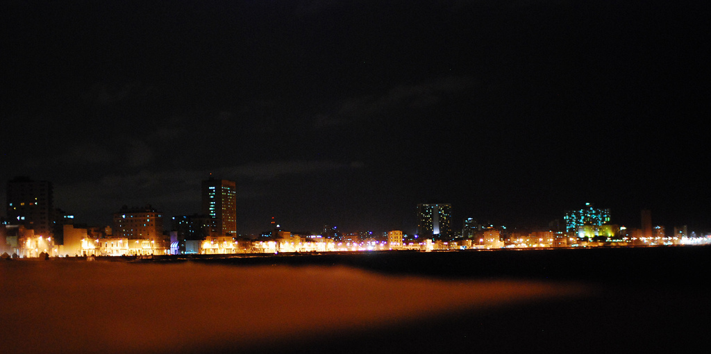 Only the lights of the long strip of buildings along the Malecon are visible.