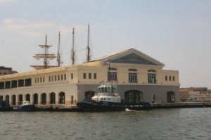 A tugboat floats outside a port terminal building.
