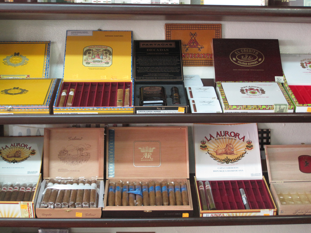 Open boxes of cigars on shelves in a shop.