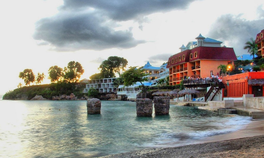 Water lapping onshore in front of a multi-level hotel..