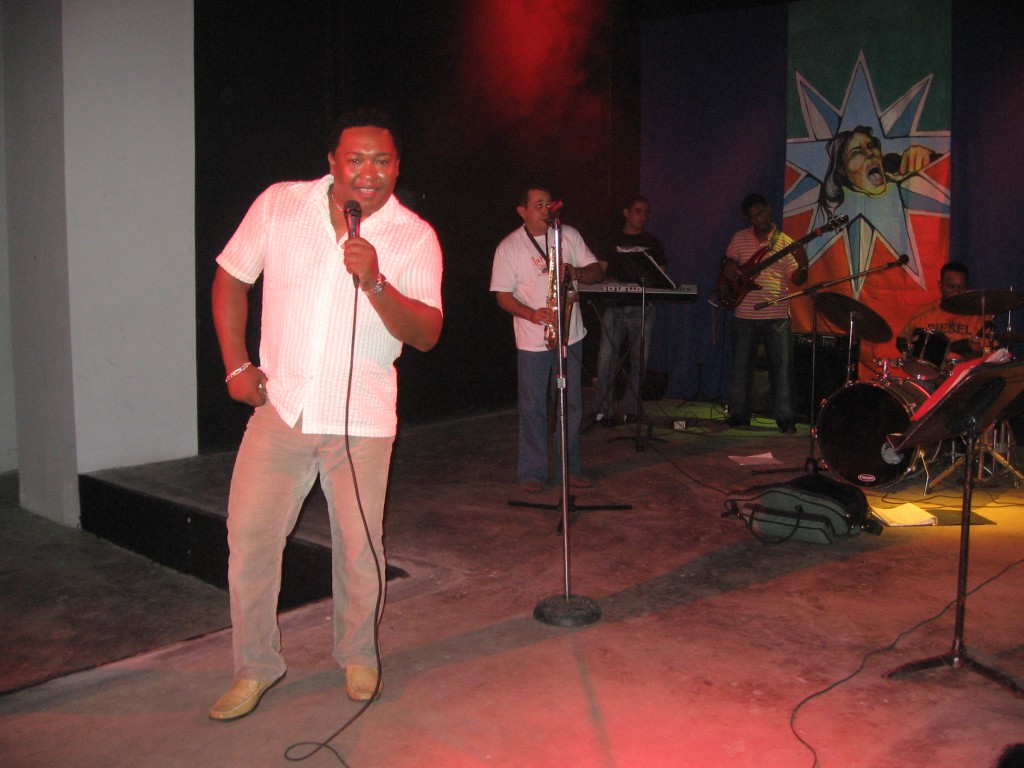At the forefront of a live band, a singer has the mic.
