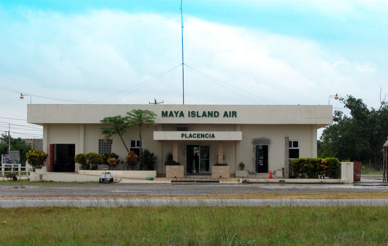 A single-story building designated Maya Island Air next to a simple airstrip.