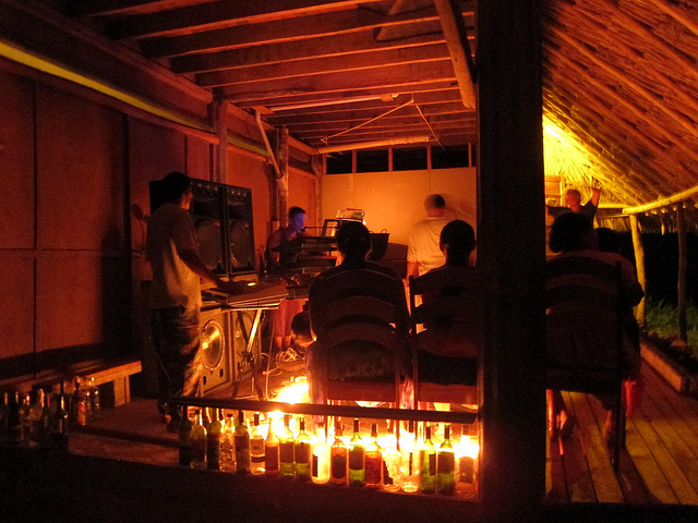 A small group of people enjoying a performance by a local band in Belize.
