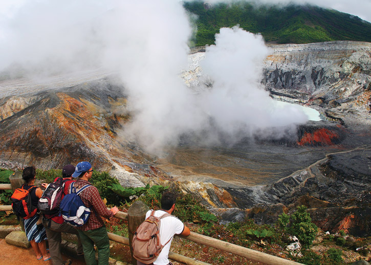 Visitors gazing into the main the crater of Poás Volcano.
