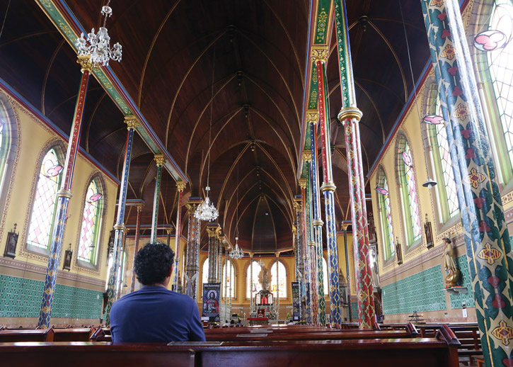 A man sits in a pew inside Iglesia Nuestra Señora de las Mercedes, San José, Costa Rica.