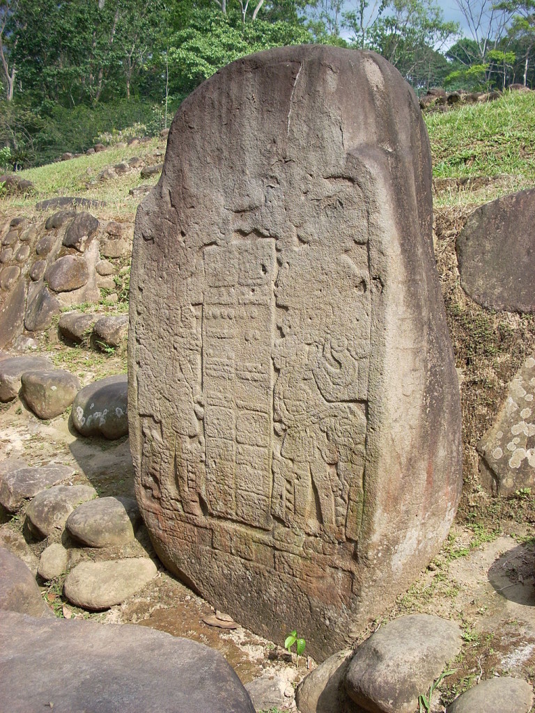 Stela 5 at Takalik Abaj. Photo © Simon Burchell (Own work) [<a href="http://creativecommons.org/licenses/by-sa/3.0">CC BY-SA 3.0</a>], <a href="https://commons.wikimedia.org/wiki/File%3ATakalik_Abaj_Stela_5.JPG">via Wikimedia Commons</a>.