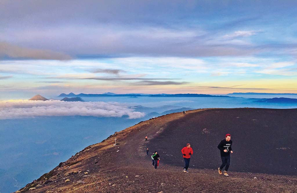 Hikers running along the crater of Acatenango Volcano. Photo © Al Argueta.