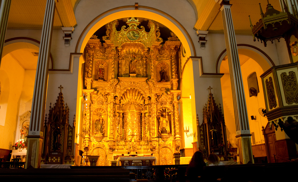 Underlit, the ornate golden altar reflects warm light.