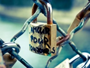 Hanging on a fence, a lock with L'amour pour tou jours written on it.