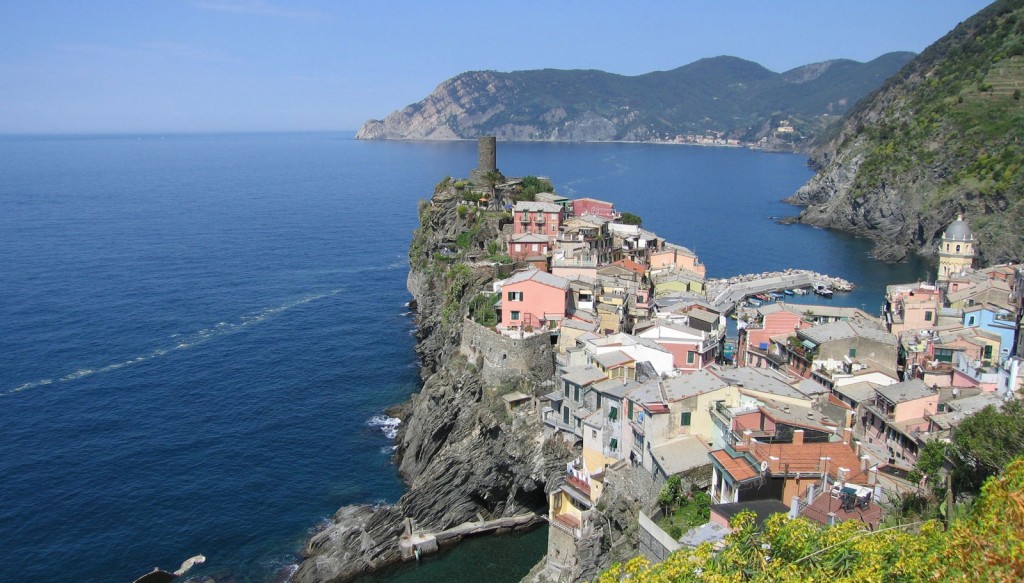 Houses cluster on a narrow peninsula that rises up on steep rocky cliffs above the ocean.