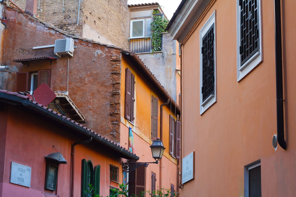 View of multi-story buildings in warm colors clustered along a narrow street.