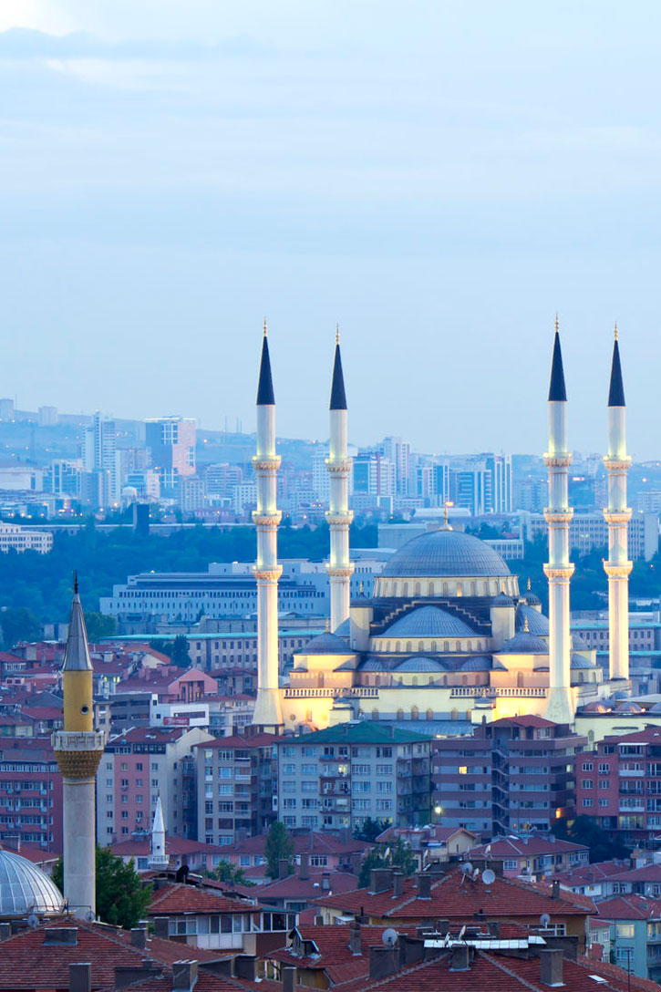 At dusk, lights illuminate the minarets of the Kocatepe Mosque in Ankara.