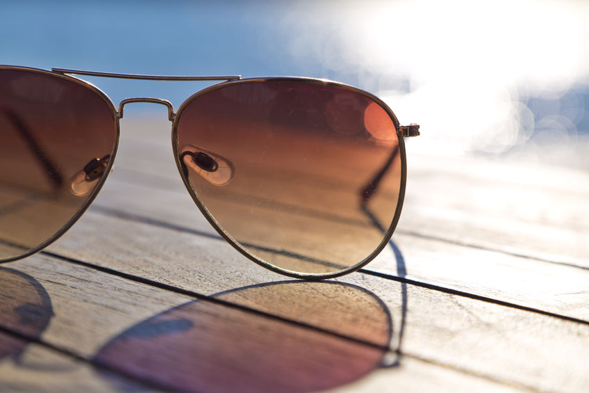 A pair of tinted aviator sunglasses on a table.
