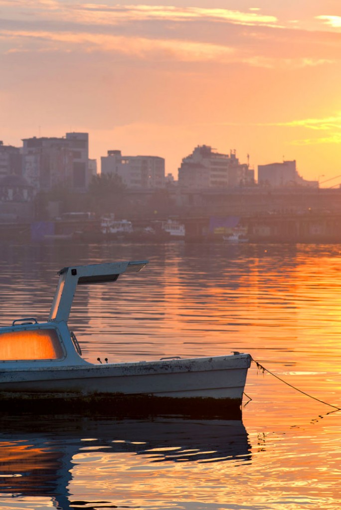 An orange sunrise reflects on the water of Istanbul's Golden Horn.