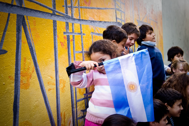 A young girl holds up the Argentinian flag at Expanish language school in Buenos Aires.