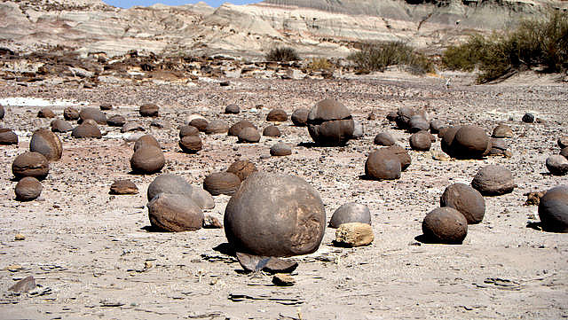 Spherical rocks are scattered across a dry-looking valley.