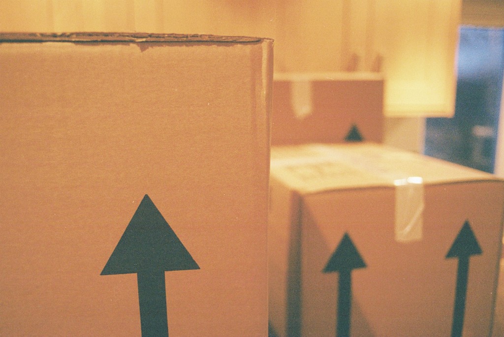 Close up view of the up arrows on the side of closed cardboard moving boxes.