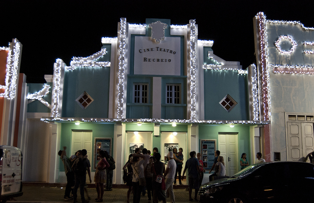 The front of a building strung with lights and a sign reading Cine Teatro Recreio.