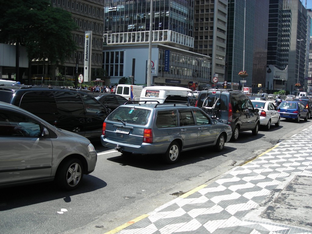 Cars wait in bumper to bumper traffic on a city street.