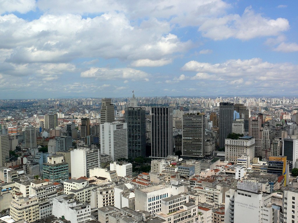 Clouds scatter across the sky above Sao Paulo's clustered cityscape.
