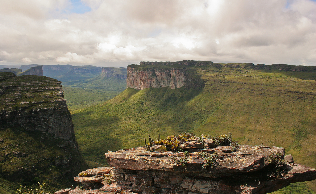 View across the plateaus with cliffsides visible rising up out of verdant green slopes.