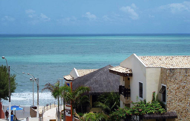 Beyond quaint buildings with tile roofs, the ocean stretches to the horizon.